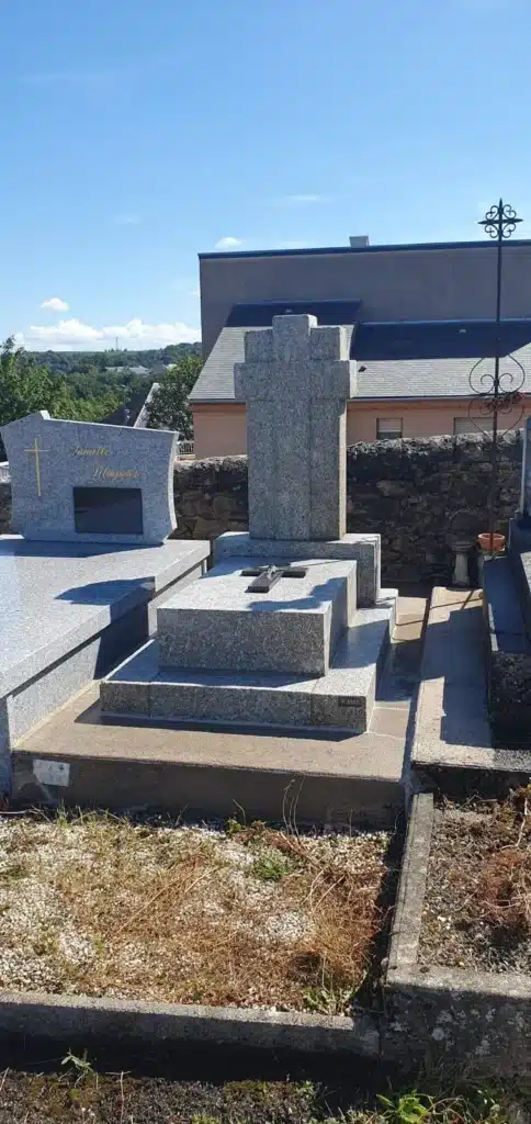 monument-funeraire-stele-granit Monument funéraire en granit avec une grande stèle en forme de croix, installé dans un cimetière, conçu pour un hommage durable et élégant. 